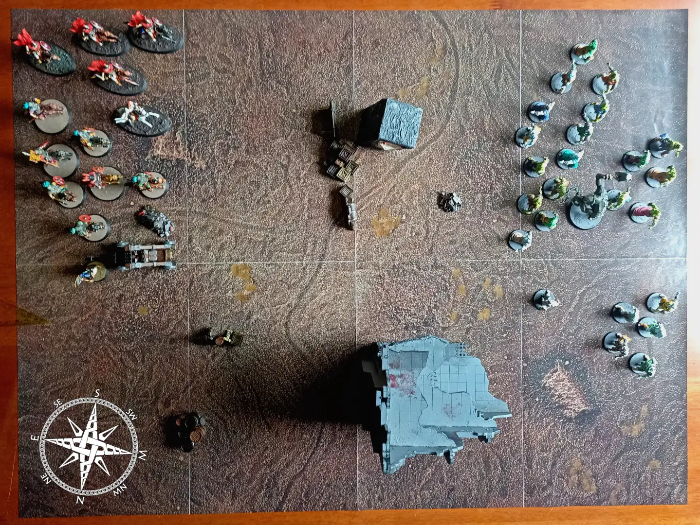 Battle map with Romans on the left, orcs on the right, and terrain obstructions down the middle.